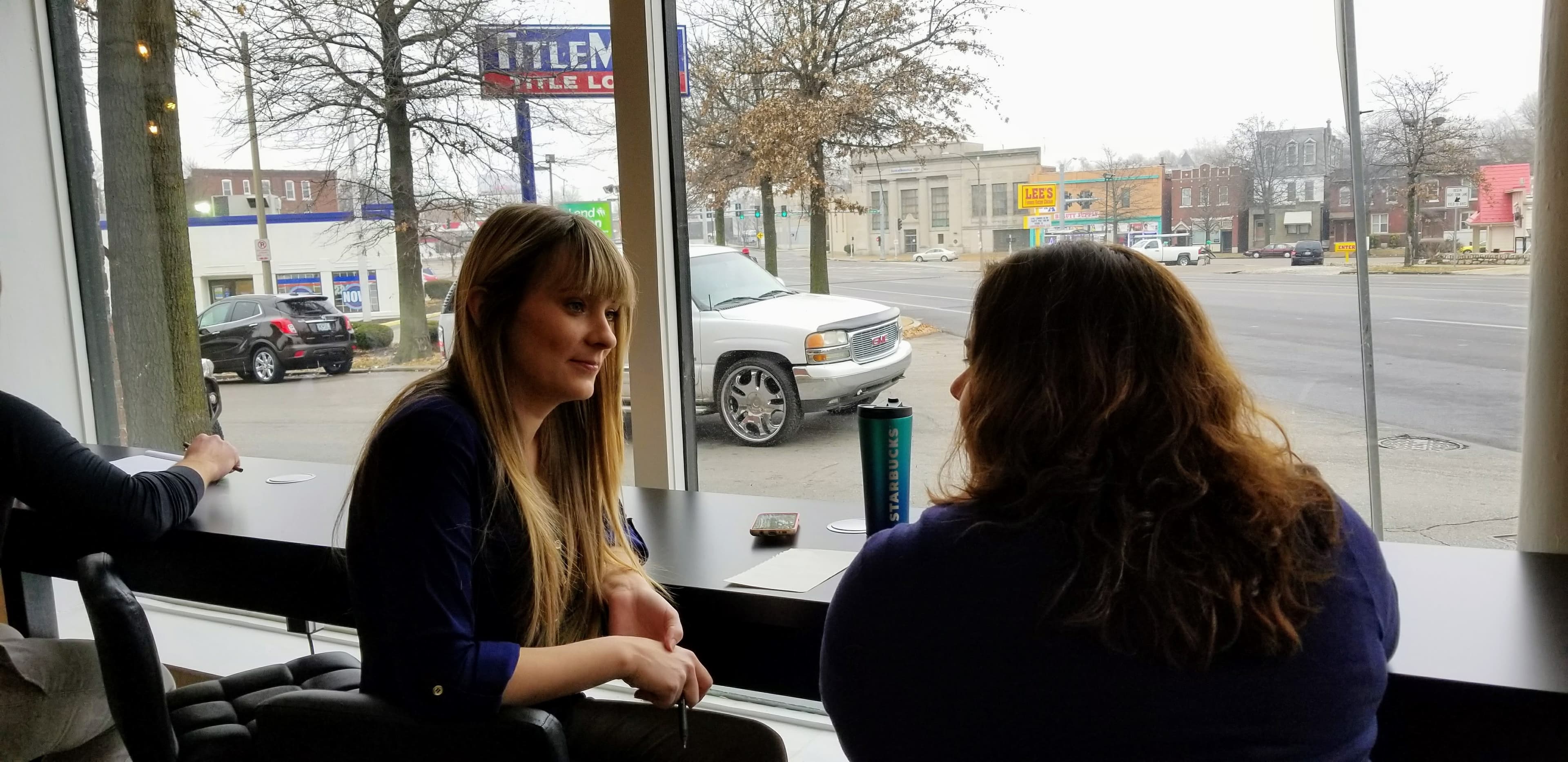 Two members in conversation at a window counter before a BusinessGPS meeting